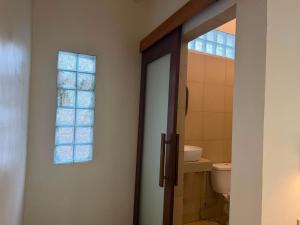 a bathroom with a toilet and a window at Hotel Orangutan in Bukit Lawang +42 photos