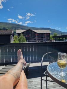 a person laying on a deck with a glass of wine at Nice appartment in city center Gol,free Wifi and electric in Gol