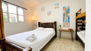 a bedroom with a large bed with white sheets at Casa Hotel Terraza del Cabrero in Cartagena de Indias