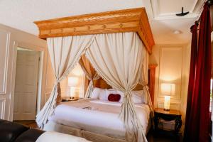 a bedroom with a canopy bed with white sheets at Woodrow House Bed & Breakfast in Lubbock +78 photos
