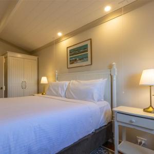 a bedroom with a large white bed and two lamps at Cape Nelson Lighthouse in Portland