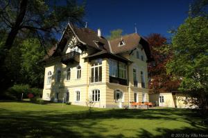 ein großes weißes Haus mit braunem Dach in der Unterkunft Villa Nova - Hotel garni in Waidhofen an der Ybbs