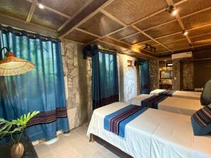 two beds in a room with blue curtains at homestay bongbang in Ha Giang +189 photos