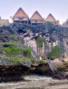 a house on top of a cliff next to the ocean at Aresona Cliff House in Bira +18 photos