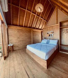 a bedroom with a large bed in a wooden room at Aresona Cliff House in Bira