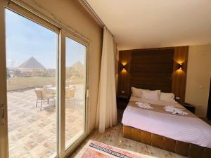 a bedroom with a bed and a view of the pyramids at House Pyramids View Hotel in Cairo +44 photos