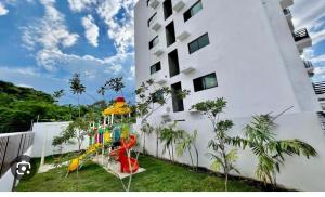 a backyard with a playground next to a building at Torre con ascensor y vigilancia in Santiago de los Caballeros