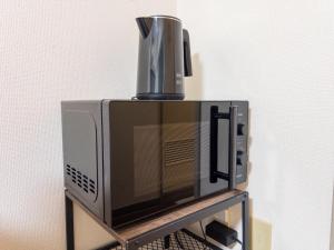 a microwave oven with a cup on top of it at Ichigaya Stay & Wi-Fi 1 in Tokyo +145 photos