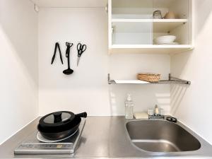 a kitchen counter top with a sink and a stove at Ichigaya Stay & Wi-Fi 1 in Tokyo