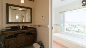 a bathroom with a sink and a mirror and a tub at Auberge Bonne Chere Raout in Onna