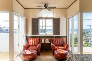 a living room with two leather chairs and a table at Auberge Bonne Chere Raout in Onna