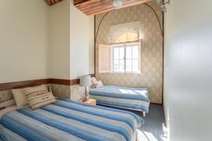 two beds in a bedroom with a mirror at Auberge Bonne Chere Raout in Onna