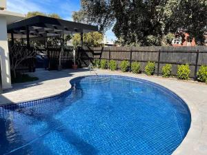 a swimming pool in a yard next to a fence at Taft Apartments in Adelaide