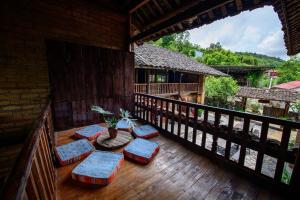 a porch of a house with chairs and a balcony at homestay bongbang in Ha Giang