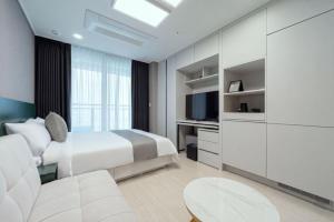 a bedroom with a bed and a couch and a tv at Bella Stay in Chuncheon