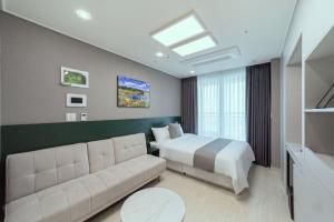 a hotel room with a bed and a couch at Bella Stay in Chuncheon