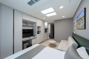 a bedroom with a white bed and a television at Bella Stay in Chuncheon