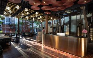 a restaurant with a bar with tables and chairs at The Palace Indochine Hotel in Siem Reap