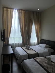 a bedroom with two beds and a window at Qu Lin Resident in Sibu