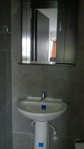 a white sink in a bathroom with a mirror at Apartaestudios El Cable in Manizales
