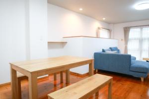 a living room with a table and a blue couch at Danran HAKATA in Fukuoka