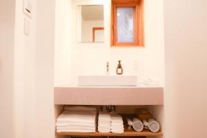 a bathroom with a sink and a mirror and towels at Danran HAKATA in Fukuoka +17 photos