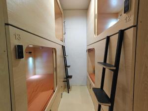 a small room with wooden cabinets and a hallway at Sleepy Bear Capsule Hostel in Johor Bahru