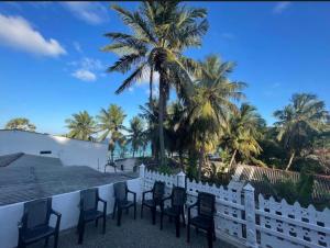 a row of chairs on a balcony with palm trees at NRT Beach Hotel in Trincomalee