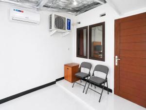 a room with two chairs and a desk and a door at Nata Hotel Tasikmalaya in Gunungcupu