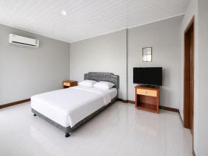 a bedroom with a bed and a flat screen tv at Nata Hotel Tasikmalaya in Gunungcupu +15 photos