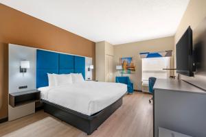 a hotel room with a bed and a flat screen tv at Best Western Forsyth-Decatur in Forsyth