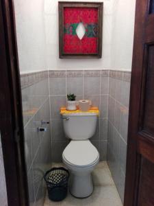 a bathroom with a toilet with a picture on the wall at Casa De Leon in Antigua Guatemala
