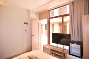 a living room with a flat screen tv and a window at KHAMI HOUSE Resort in Panglao Island