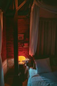 a bedroom with a bed and a table with a lamp at HIDDEN HEAVEN Rumah Barong in Jasri