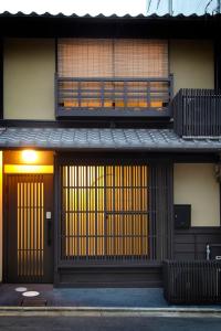 ein Gebäude mit zwei Türen und einem Balkon in der Unterkunft Machiya Momiji in Kyoto