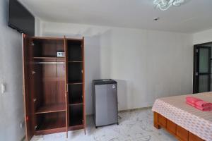 a room with a bed and a small refrigerator at Jasmin Czechinn in Dauis