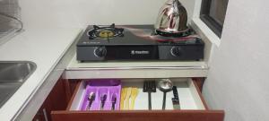 a stove and utensils in a drawer in a kitchen at Casa Sajama 121 in La Paz