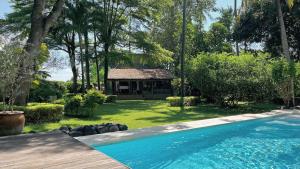 a swimming pool in a yard with a house at HIDDEN HEAVEN Rumah Barong in Jasri