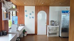 a room with a kitchen with a door and a refrigerator at The Pearl Seaview in Fulidhoo