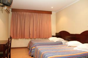 a bedroom with a bed and a desk at Residencial Bela Star in Porto