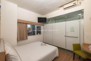 a bedroom with a bed and a glass wall at Whiz Hotel Falatehan Jakarta in Jakarta