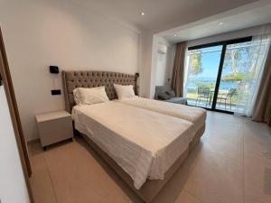 a bedroom with a large bed and a large window at Captains Studios & Apartments in Kavos +62 photos