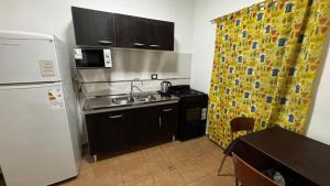 a small kitchen with a refrigerator and a sink at Soles del Boulevard in Córdoba