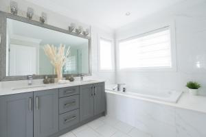 a bathroom with a sink and a tub and a mirror at 5-Star Luxury and comfortable home in New Westminster +50 photos