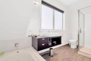 a bathroom with a tub and a sink and a toilet at Matamata Central Motel in Matamata +38 photos