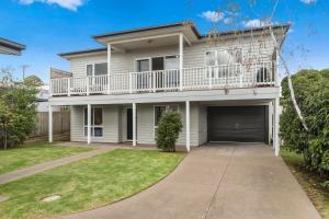 a white house with a balcony and a driveway at San Remo Bay Views Phillip Island Gateway in San Remo