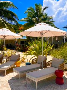 a group of chairs and umbrellas on a beach at Opoa Beach Hotel in Opoa
