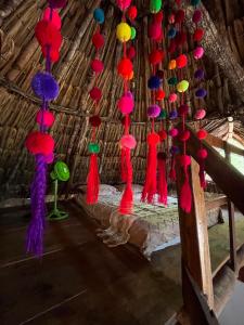 a room with colorful tassels hanging from the ceiling at Eco Hacienda ICH-KI in Hoctún
