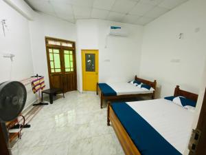 a room with two beds and a yellow door at Thuru Sisila Resort in Anuradhapura +27 photos