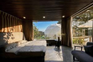 a bedroom with a bed and a large window at Chanchill Glamping&cafe in Xuân Thọ